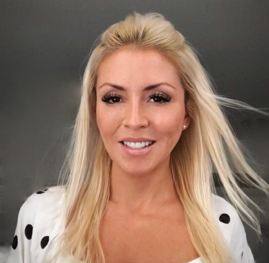 Carolina, founder of Carolina Posh, wearing a leopard print top and smiling in a professional lifestyle setting.