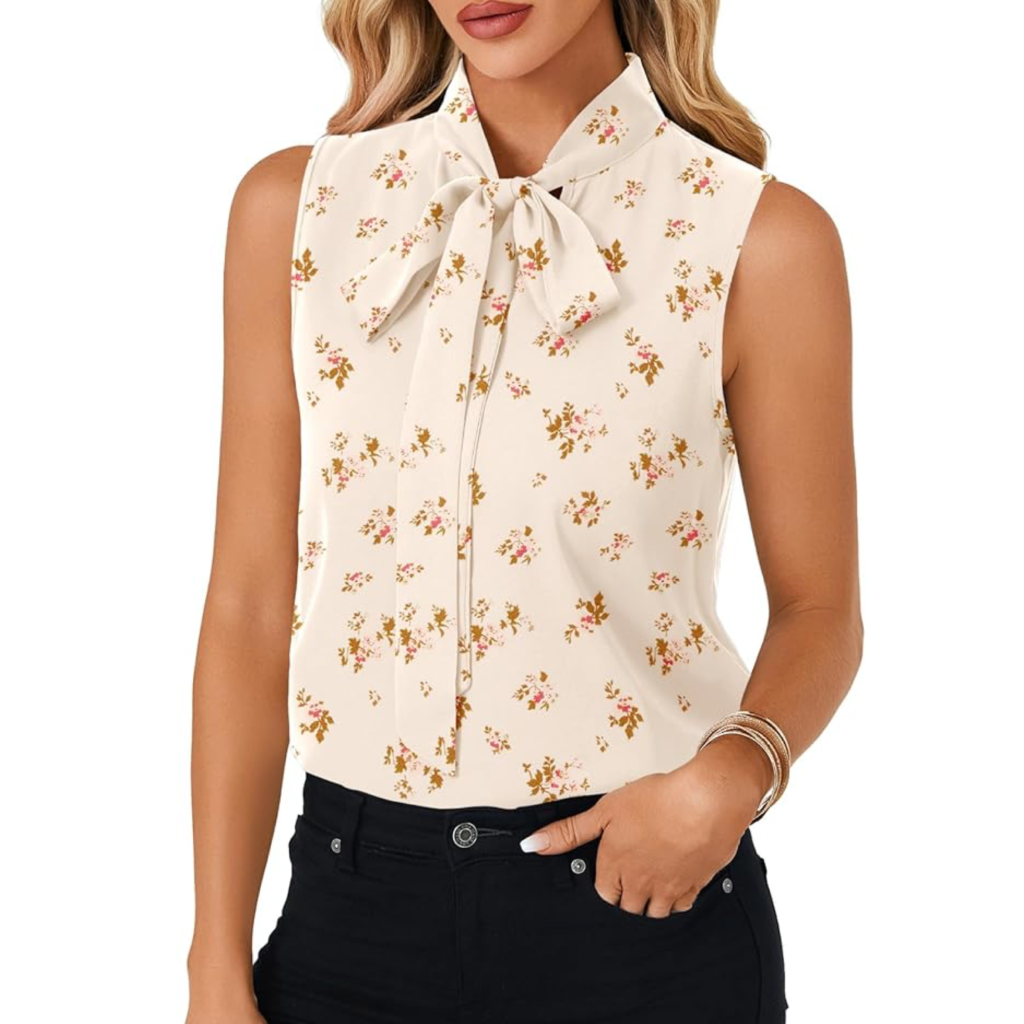 A woman wearing a sleeveless cream-colored bow tie blouse with a delicate floral print, styled with black trousers for a feminine and polished summer look