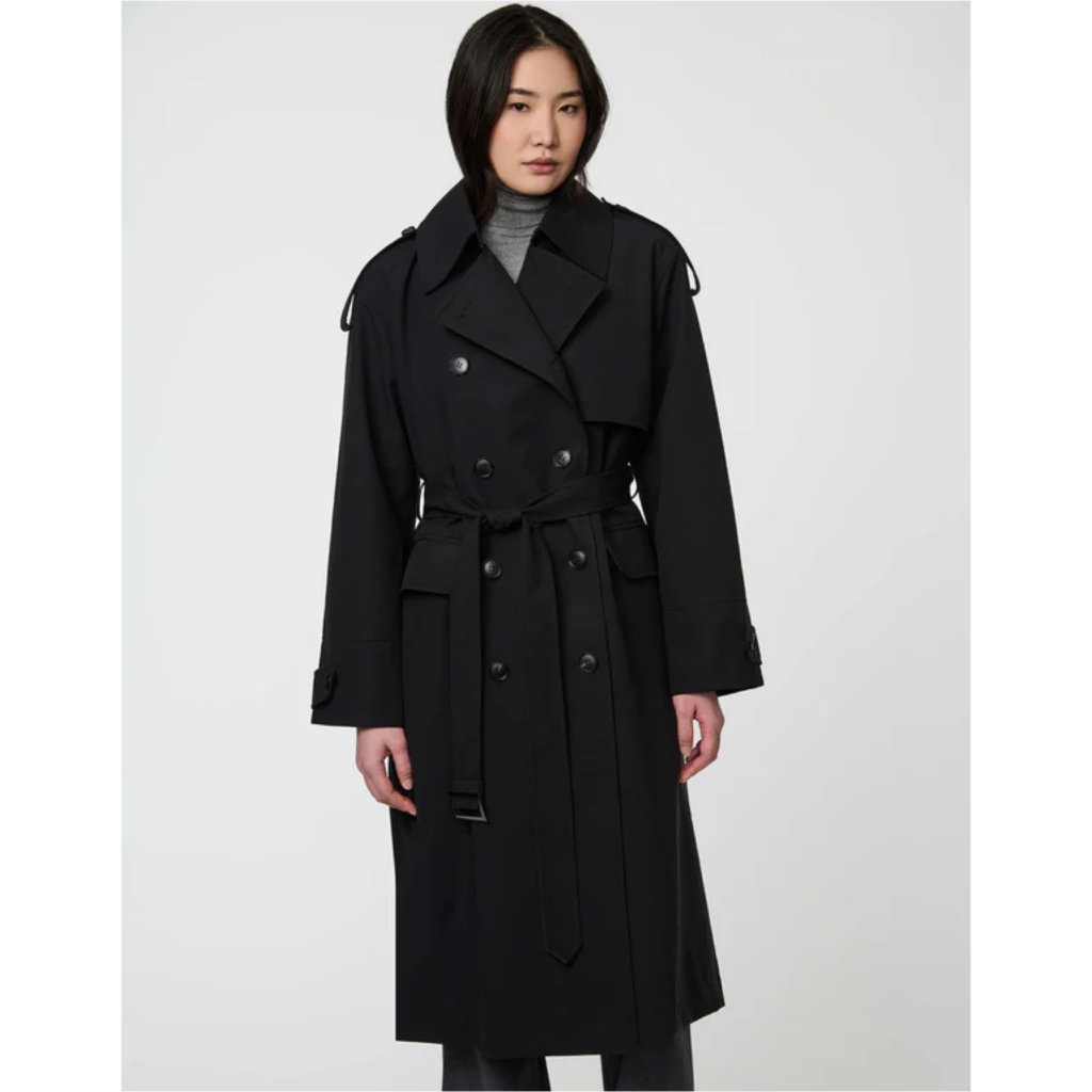 A woman wearing the Bernardo Highgate black trench coat, a long single-breasted duster with a structured collar and a belted waist.