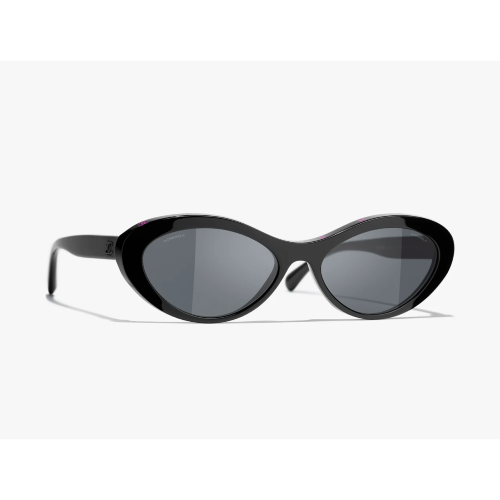A pair of Chanel Oval Sunglasses in black acetate, featuring the subtle double-C logo on the temples and dark lenses for a sophisticated 90s minimalist look.